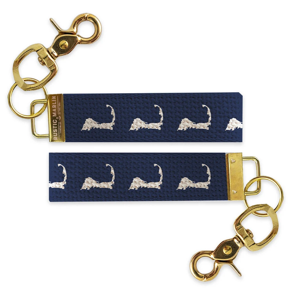 Navy blue Cape Cod wristlet keychain with repeating white Massachusetts Cape Cod silhouettes and gold-tone hardware.