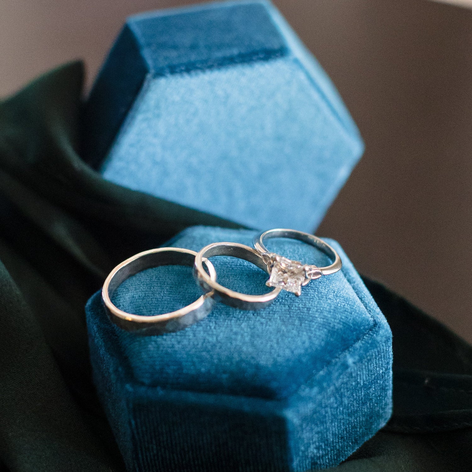 Two rings on a blue jewelry box with a blurred background